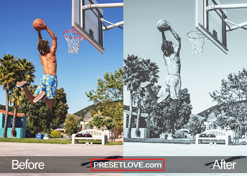 A soft blue monochrome photo of a man dunking a basketball