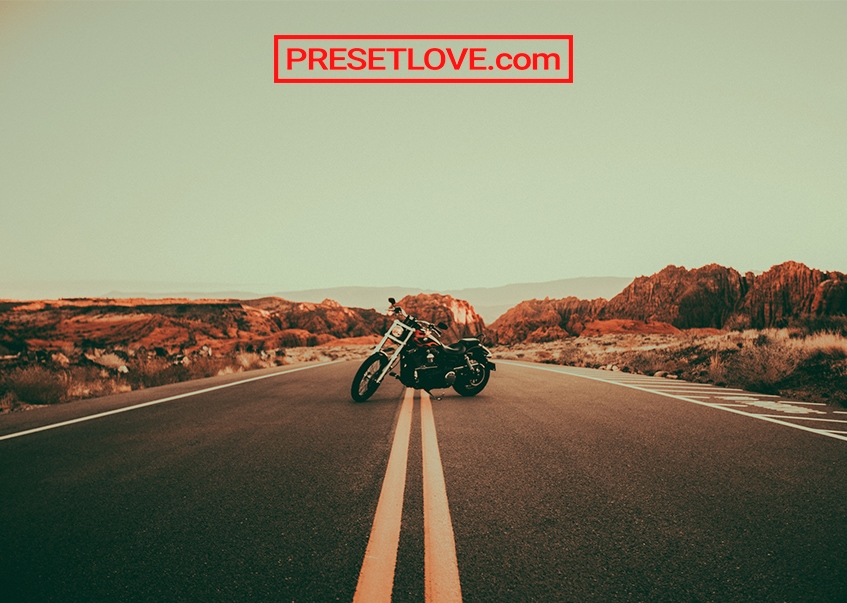 An old film photo of a motorcycle on a highway