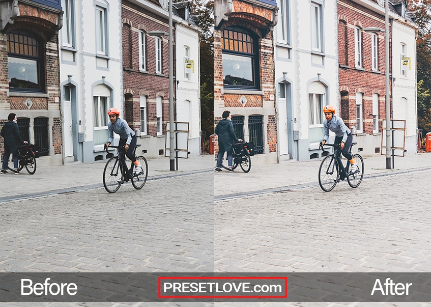 A cool retro photo of a boy riding a bike on a road lined with brick structures 