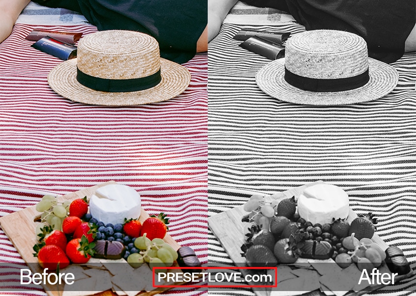 A black and white photo of a hat on top of a striped tablecloth