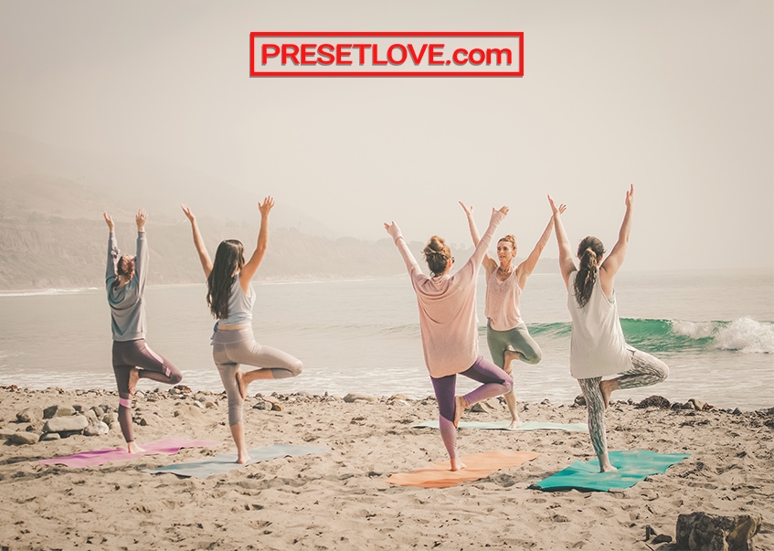 A group of women doing morning yoga at the beach