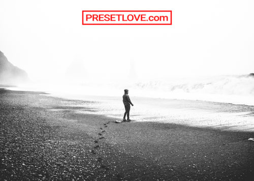 A black and white photo of a man at the beach