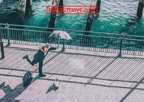 An HDR photo of a man strolling the street in a suit and an umbrella