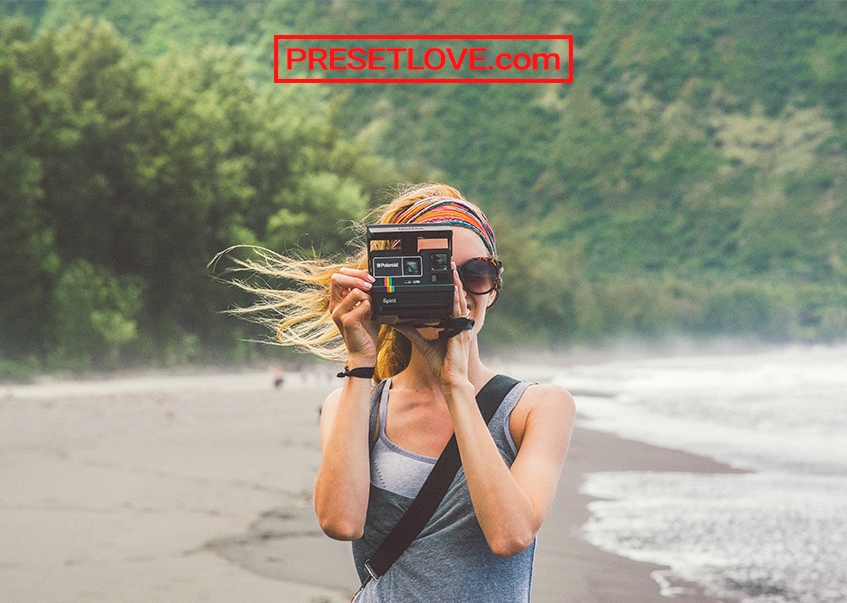 A photo of a woman shooting with a Polaroid outdoors