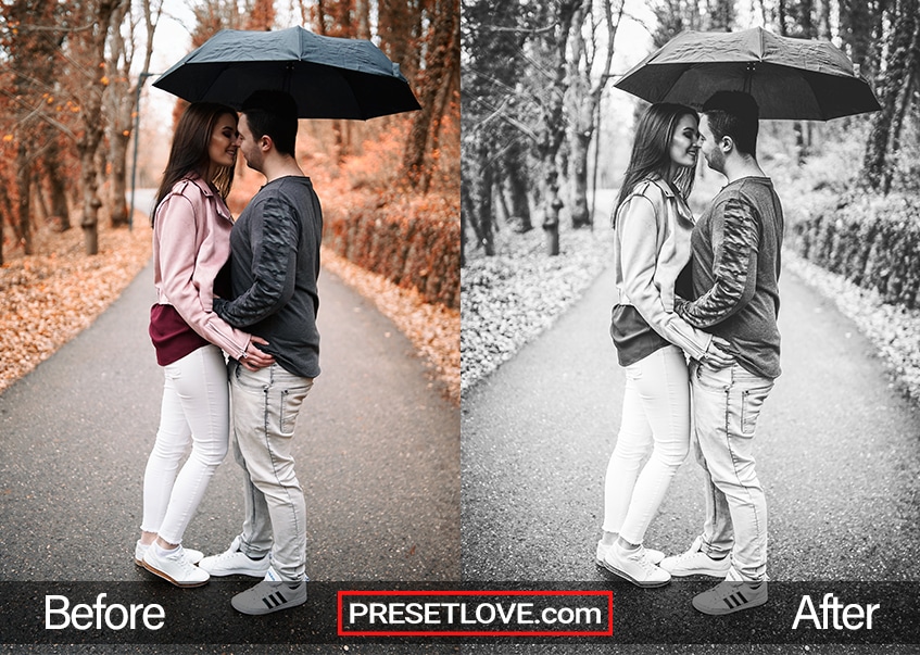 A black and white photo of a couple facing each other while standing under an umbrella