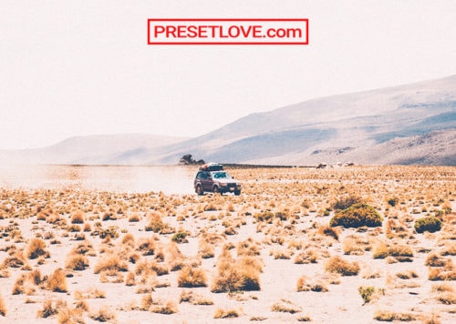 A vintage outdoor shot of a 4x4 vehicle in open terrain