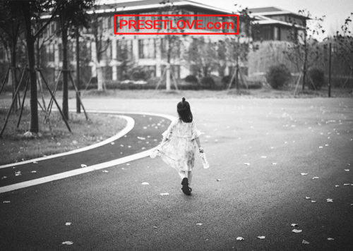 A black and white photo of a child walking on the street