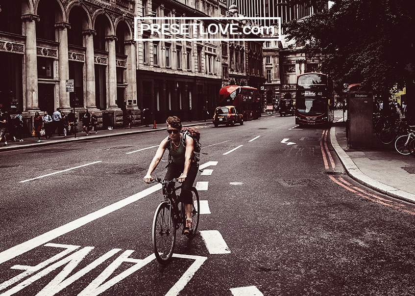 A retro photo of a man biking on a street