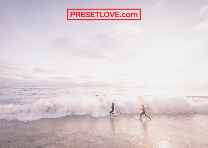 A soft photo of two people running at the beach