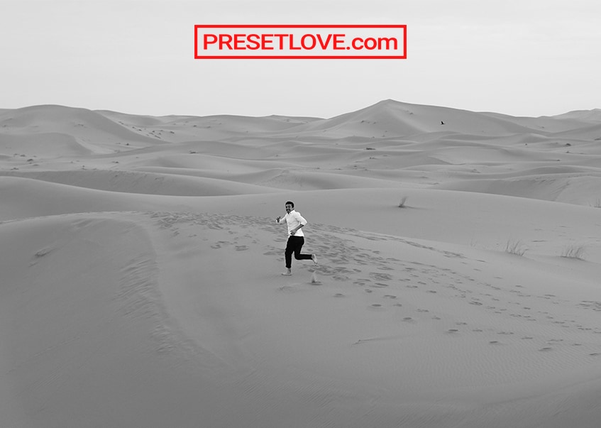 Black and white photo of a man running in a desert