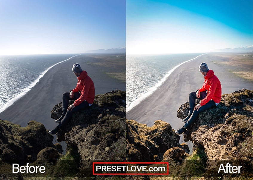 A man in a read coat sitting at the edge of a cliff