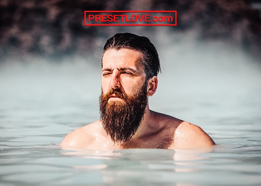 A bearded man in an outdoor spring or pool